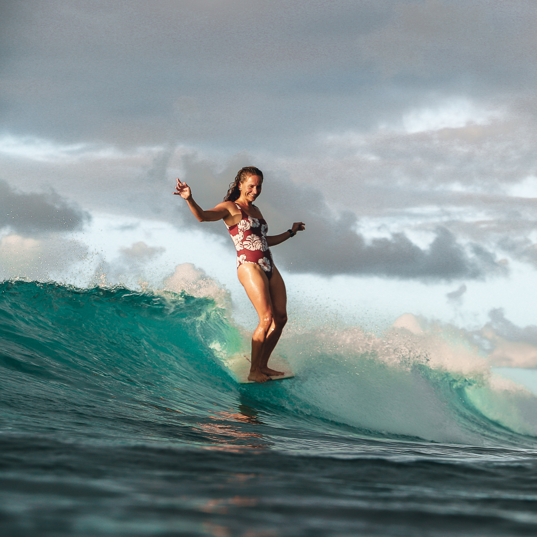Femme en train de faire un noseride sur son longboard